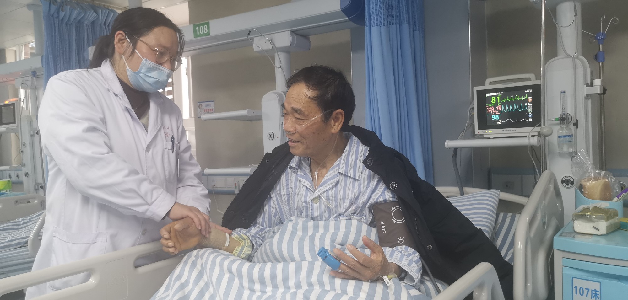 南溪山医院心内科二病区的医生为刚做完造影手术的李大爷检查身体