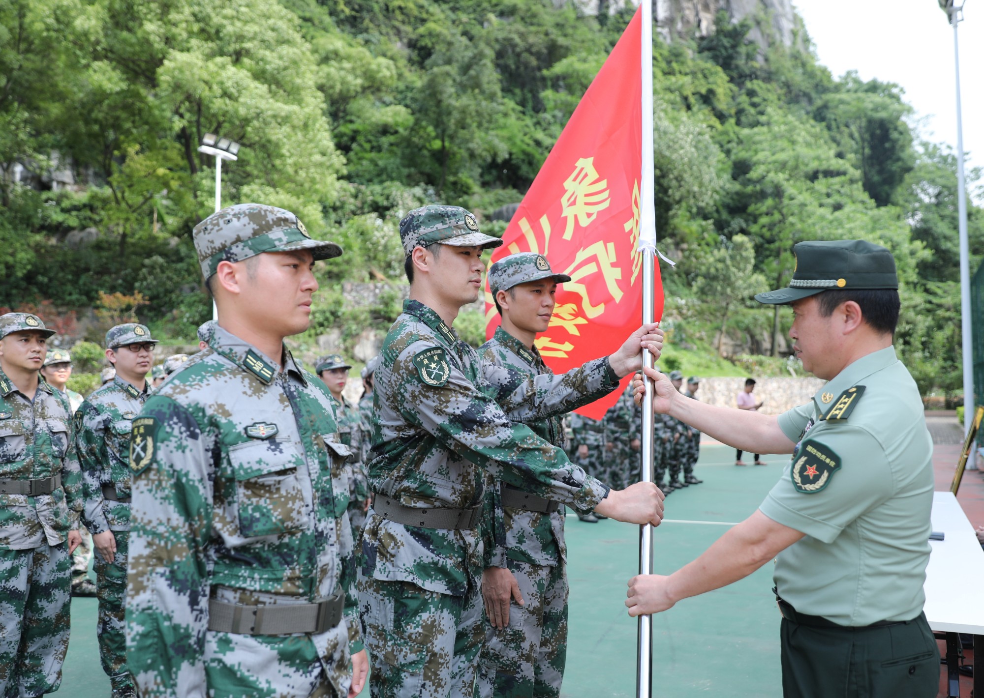 3.桂林市象山区人武部政委郑华河为自治区南溪山医院民兵团授旗