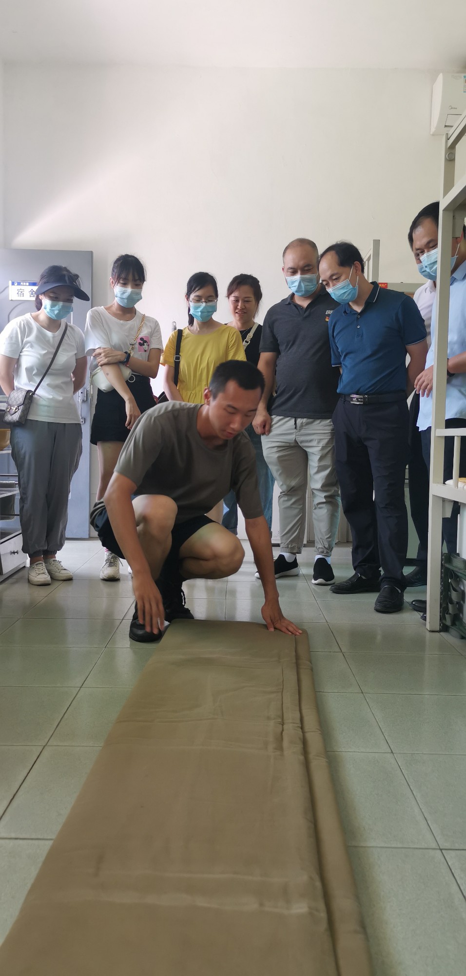 部队战士给医院党员进行叠被子展示。