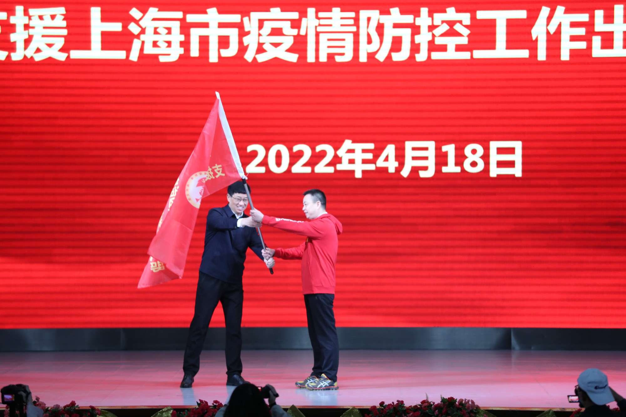 南溪山医院党委书记戴前富向医院支援上海医疗队临时党支书授旗。