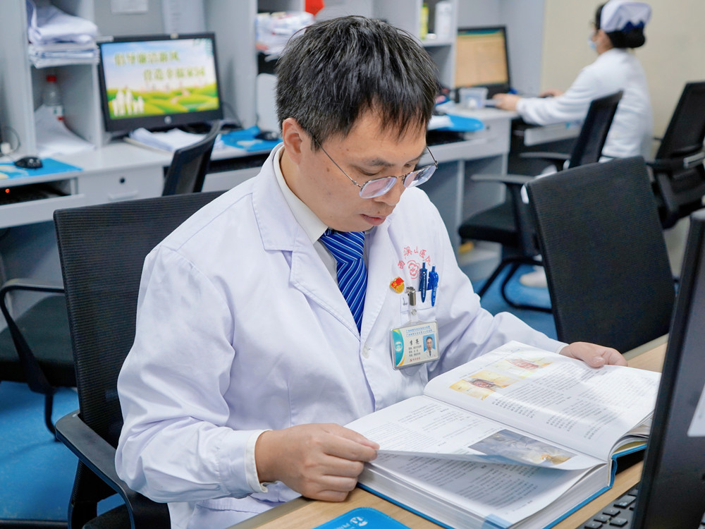 李亮在翻阅书籍 医院供图