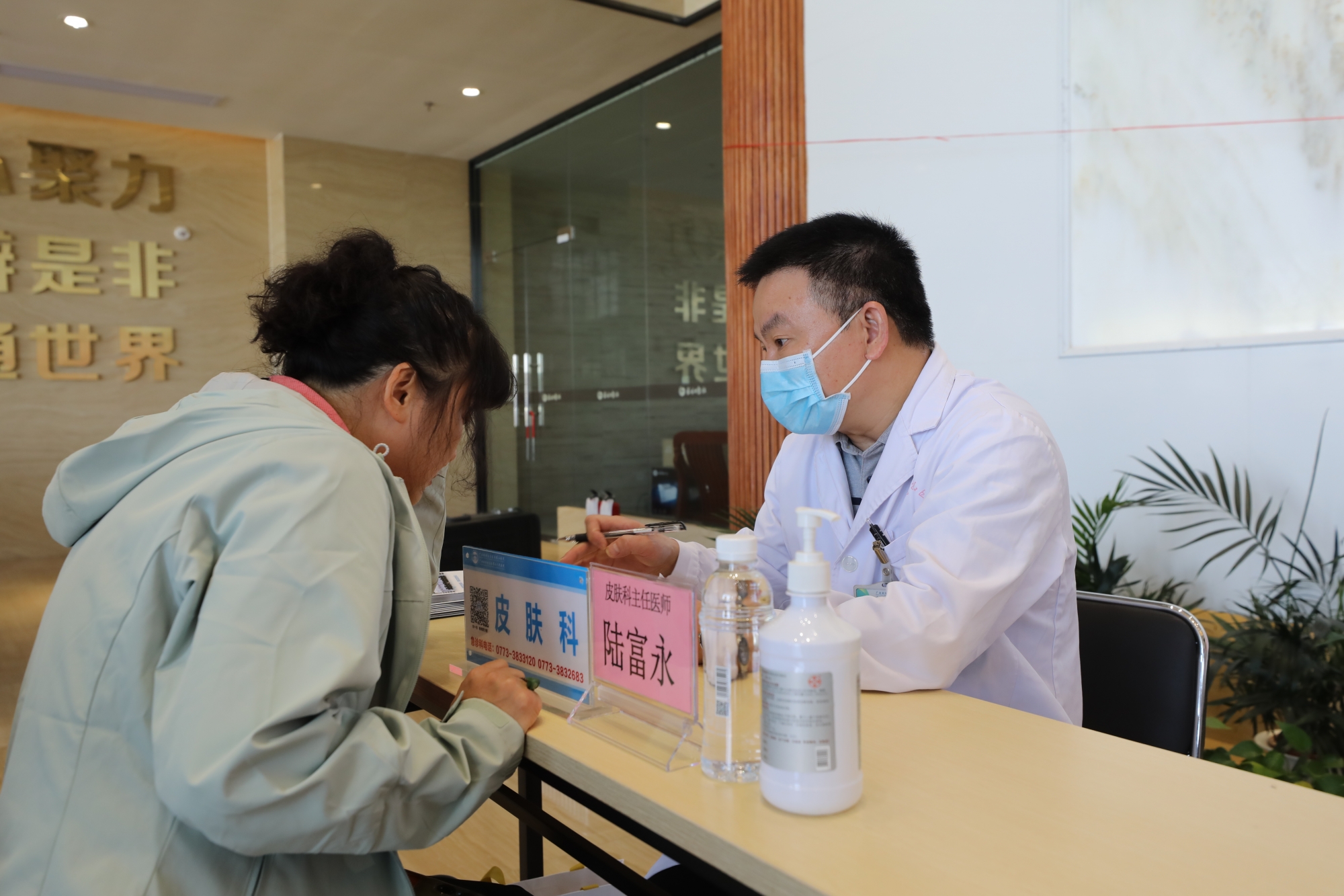 3.皮肤科主任医师陆富永在回答职工的健康咨询。